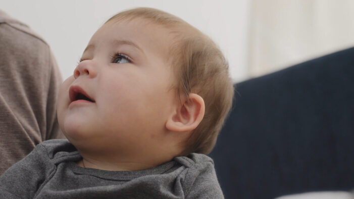 A baby is looking at their mother and trying to repeat what she said